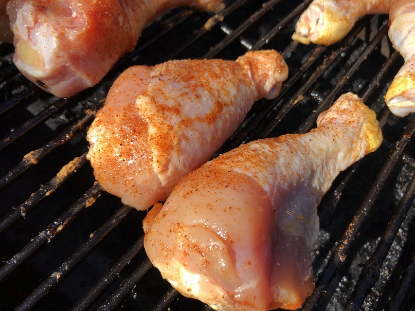 Seasoned chicken legs on grill