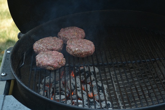 Burgers grilling over high heat