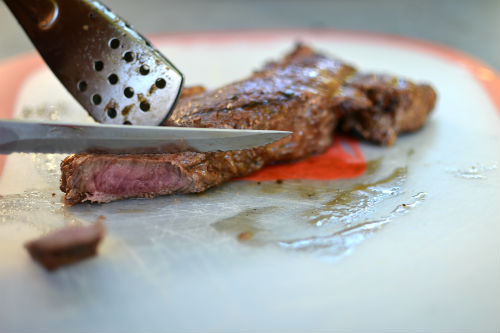 Slicing the grilled steak for sandwiches